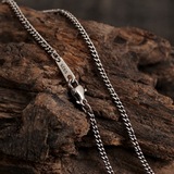 Cuban link chain draped over rustic wood, showing its links, clasp and S925 tag.