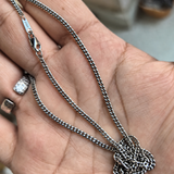 Cuban link chain pooled in an open hand, showing the clasp and S925 tag.