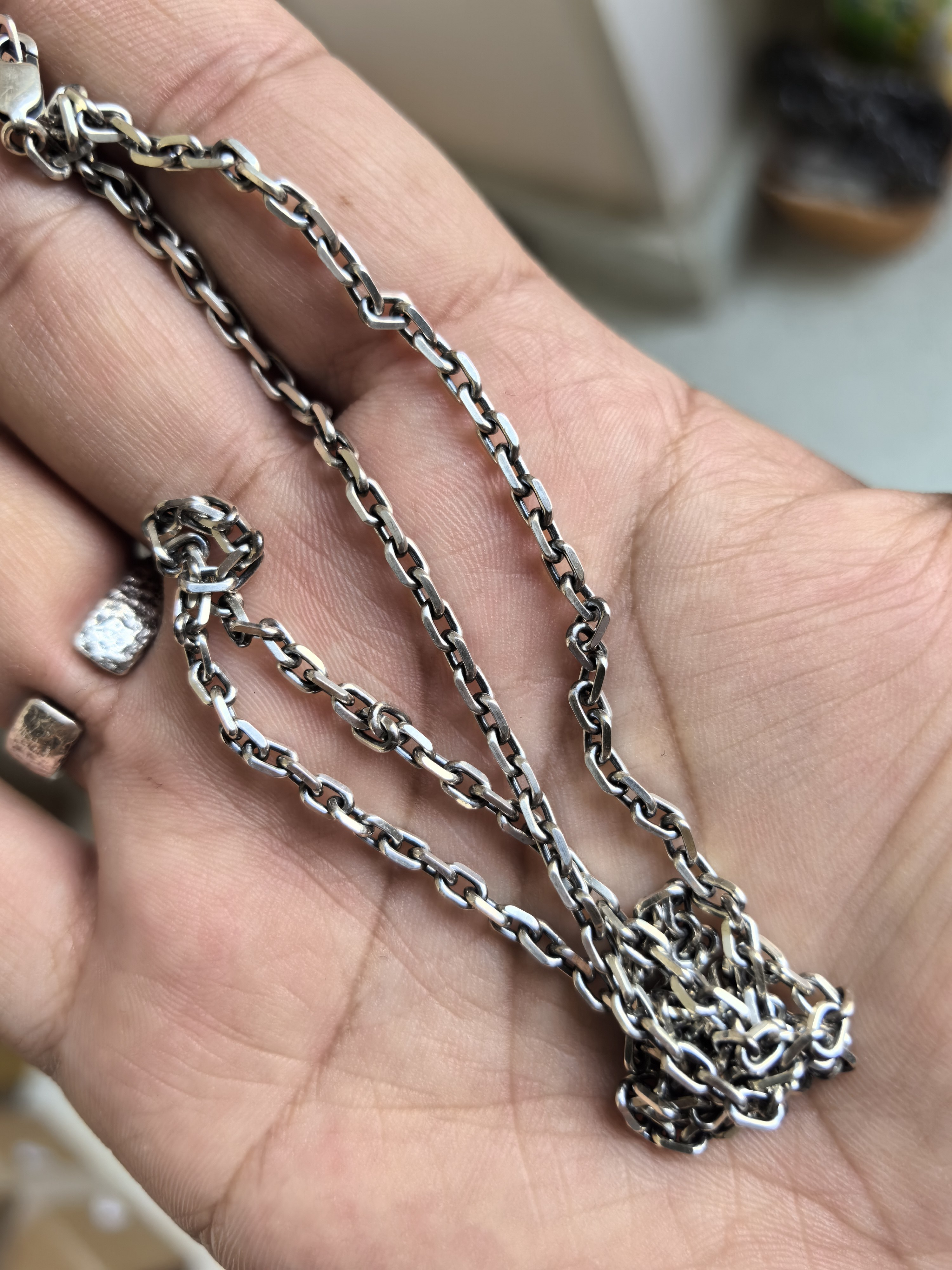Diamond Cut Curb Chain pooled in an open palm, showing the links and clasp.