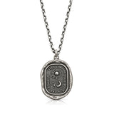 Guided by the Stars talisman pendant with sun, crescent moon and stars on a chain against a white background.